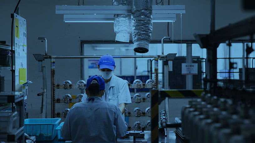 Skilled technicians managing a precision anodizing production line at the Miyaki Corporation manufacturing facility.