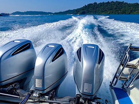 Three outboard motors on a boat, demonstrating Kashima Coat application for corrosion resistance in maritime environments.