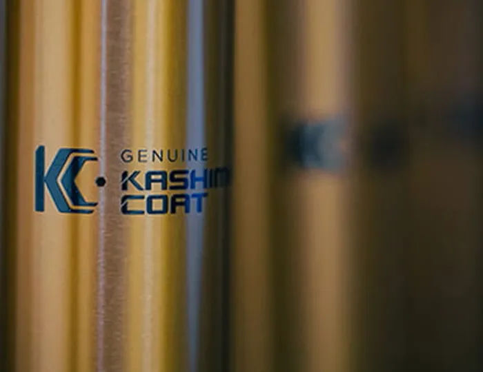 Close-up of the genuine Kashima Coat logo on a high-performance lubricated anodized aluminum suspension component.