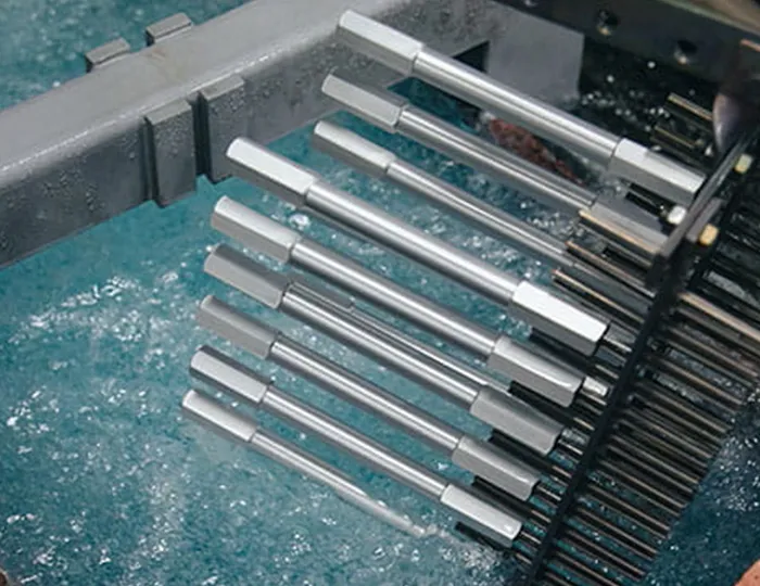 Automated anodizing line showing the immersion of aluminum parts for superior wear resistance and lubricity.
